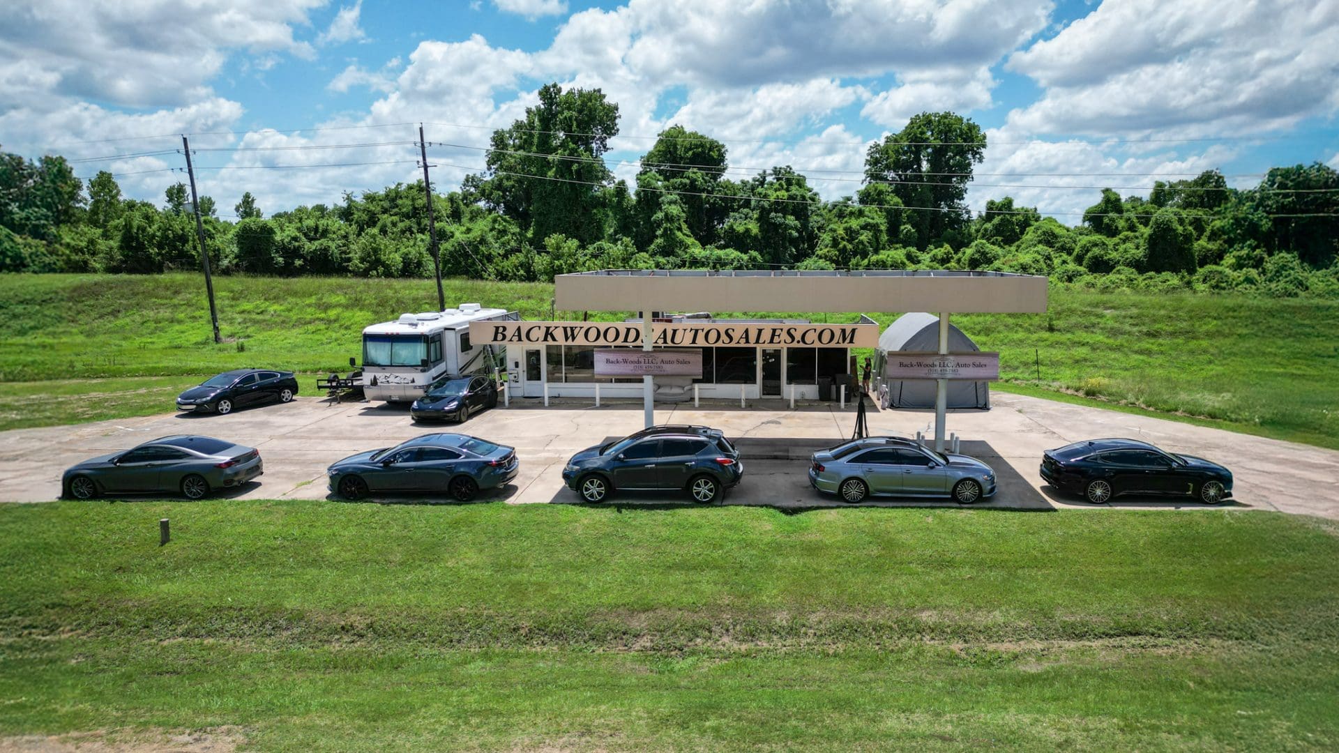 Panoramic view of BackWoods Auto Sales dealership in Bossier City LA with inventory of used cars and SUVs.